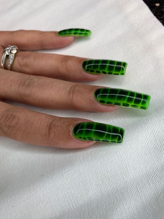 This nail art features a sleek and bold green and black snake skin pattern, exuding a sense of mystique and style. The glossy finish highlights the vibrant colors and intricate design, making it perfect for a daring and eye-catching look.