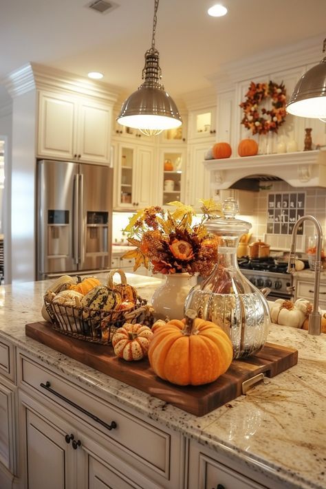 This kitchen is dressed to impress for fall, with every detail celebrating the season! The island serves as a focal point, featuring a beautiful wooden tray filled with a mix of pumpkins and gourds, alongside a sparkling glass jar and a vase bursting with vibrant autumn leaves. The warm tones of the decorations perfectly complement the creamy white cabinetry, creating a space that feels both elegant and cozy. A wreath of fall foliage graces the stove hood, tying the whole room together and making it a truly festive and inviting place to cook and gather.