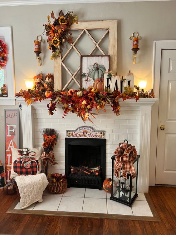 This fireplace is the heart of fall decor in this cozy living space! The white brick mantel is adorned with a lush garland of autumn leaves, pumpkins, and sunflowers, creating a vibrant focal point that screams seasonal cheer. Above the mantel, a rustic window frame serves as the backdrop for more fall accents, including a charming pumpkin painting and the word 'FALL' spelled out in decorative letters. On either side of the hearth, festive elements like plaid bows, a stack of fall-themed pillows, and a lantern filled with cozy accents complete the look. This setup is bursting with warmth and personality, perfect for celebrating the autumn season.