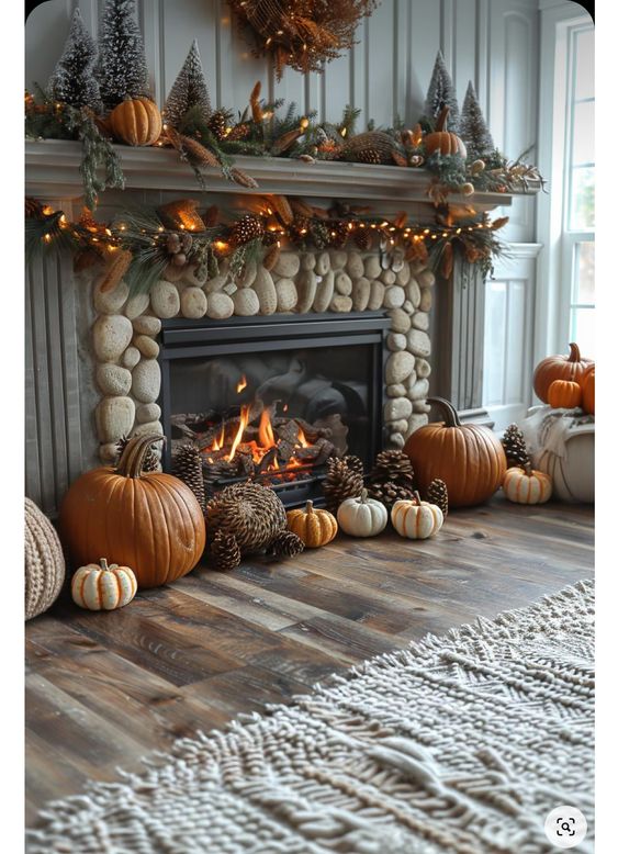 This cozy fireplace scene is the epitome of fall comfort! The stone hearth is surrounded by a delightful mix of pumpkins and pinecones, bringing the outdoors inside and adding a rustic charm to the room. The mantel is beautifully decorated with a garland of evergreen branches, pinecones, and twinkling lights, which add a warm, inviting glow. Topped with mini snowy trees and more pumpkins, the mantel brings a touch of the winter season into the autumn decor, making the transition between seasons feel seamless. The crackling fire provides a comforting warmth, while the soft, chunky knit rug enhances the cozy, inviting atmosphere. It's a perfect spot to gather with loved ones as the weather turns chilly.