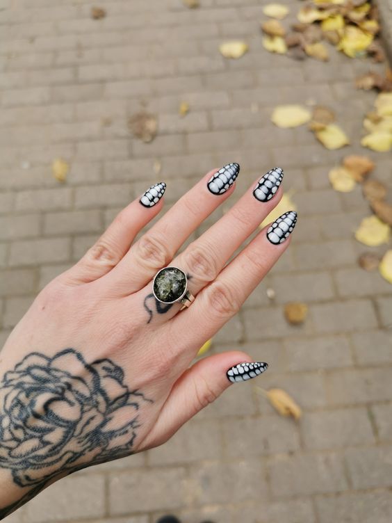 These nails feature a striking black and white snake skin pattern, creating a bold and edgy look. The glossy finish enhances the intricate scale design, making each nail a standout piece. Perfect for those who love monochrome elegance with a twist.