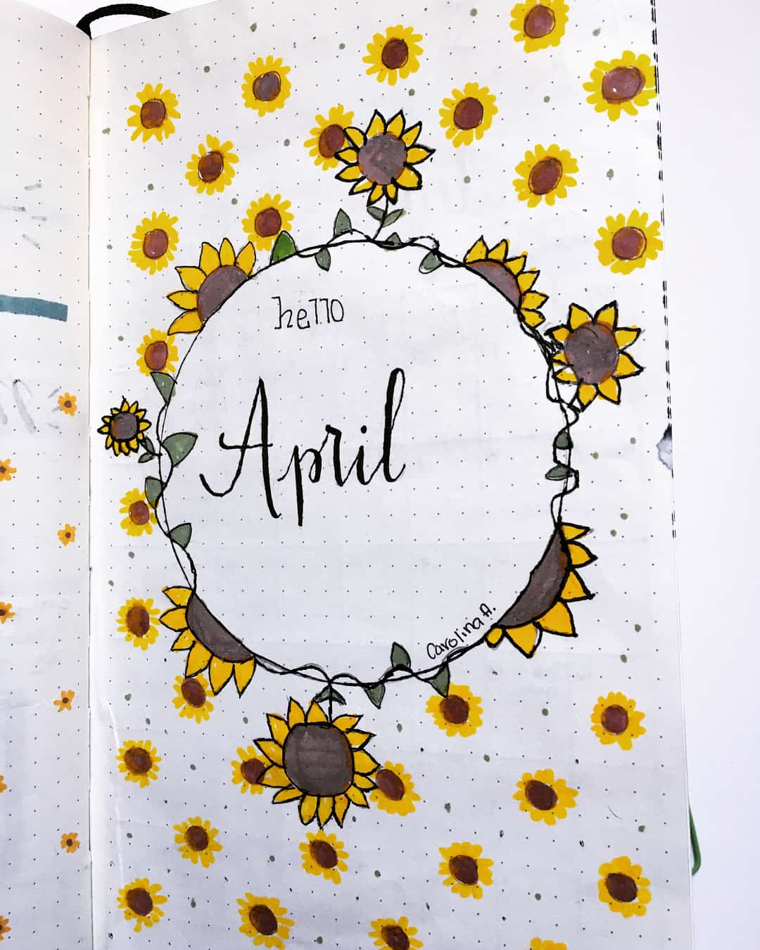 A photo of a cover page for a Bullet Journal that says Hello April and is decorated with sunflowers