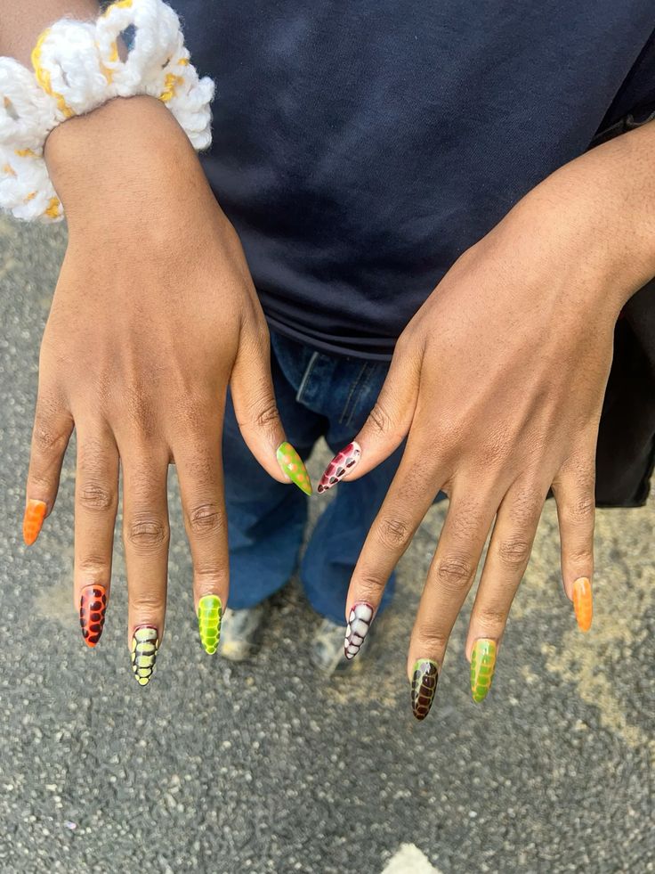 This nail art design embraces a vibrant palette with a variety of snake skin patterns in bold colors like orange, green, yellow, red, and black. Each nail is uniquely styled, creating a dynamic and colorful look that's perfect for someone who loves to experiment with edgy, nature-inspired designs.