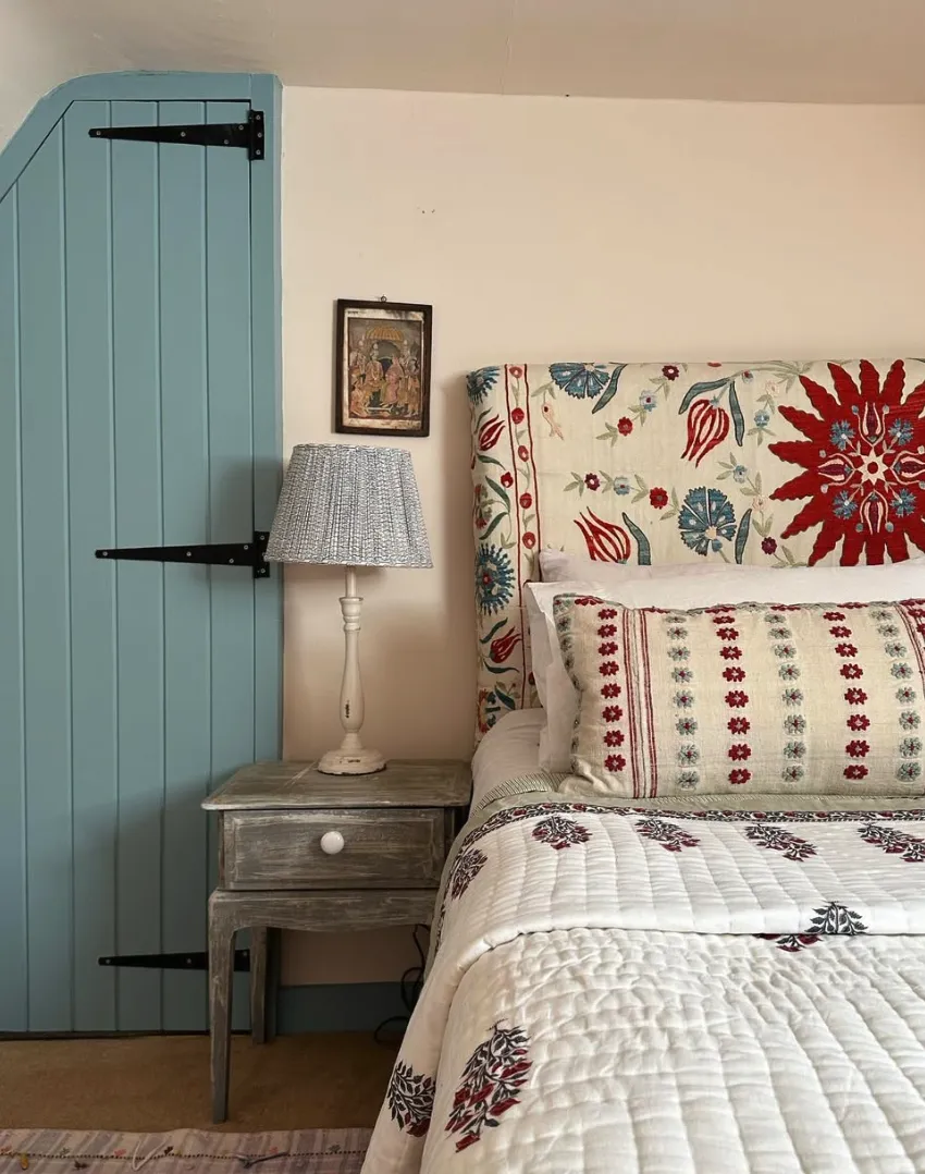 Rustic Vintage CharmA hand-stitched quilt and vintage-inspired headboard make this space feel timeless. Paired with a soft blue-painted door and an antique bedside table, this attic bedroom is perfect for those who adore traditional design.