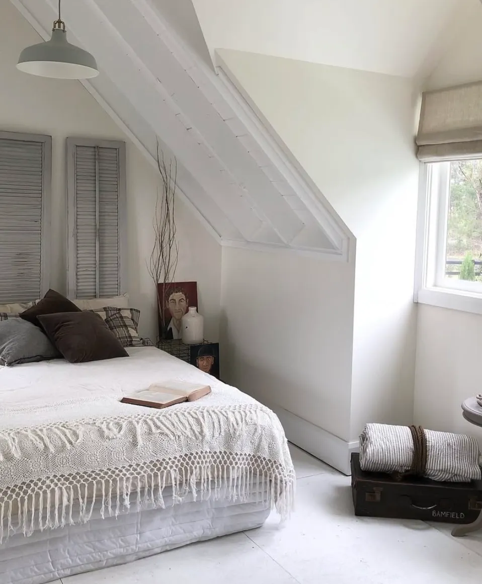 Rustic EleganceThis bedroom embraces a rustic feel with exposed beams and textured layers. The crochet bedspread and vintage suitcase add charm, while the mix of natural light and cozy accents make it a serene hideaway.