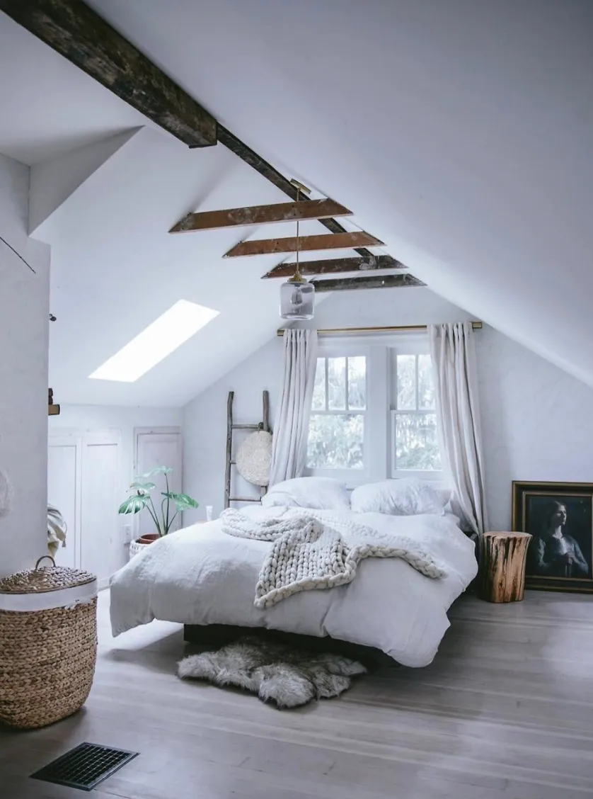 "Rustic Chic Charm" – With exposed wooden beams and soft layers of white, this room feels like a peaceful countryside getaway. The woven basket and fur rug add texture and warmth.