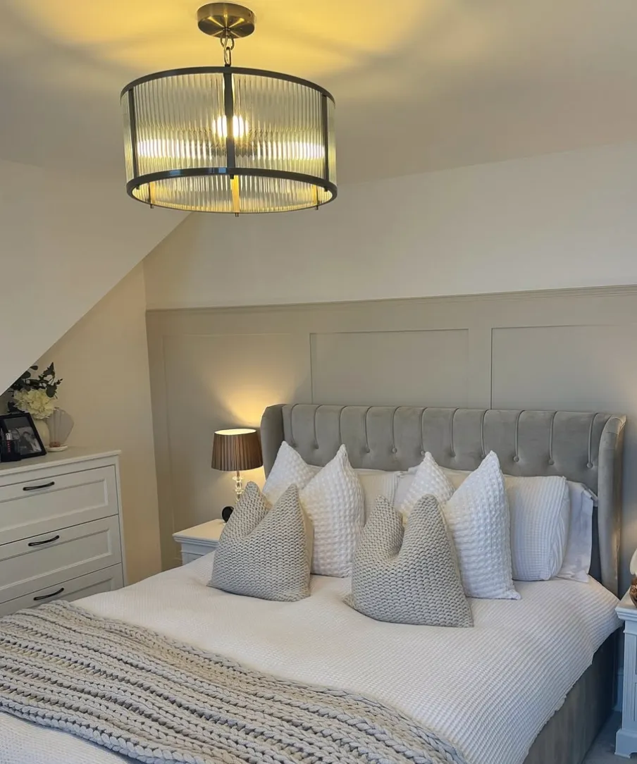 "Timeless Elegance" – This cozy guest room combines a tufted headboard with soft neutrals and textured bedding, creating a serene retreat. The warm overhead lighting ties the whole space together.