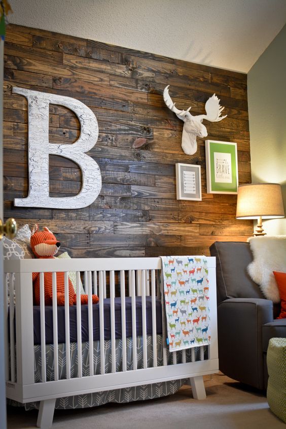 A reclaimed wood accent wall makes this a modern rustic nursery