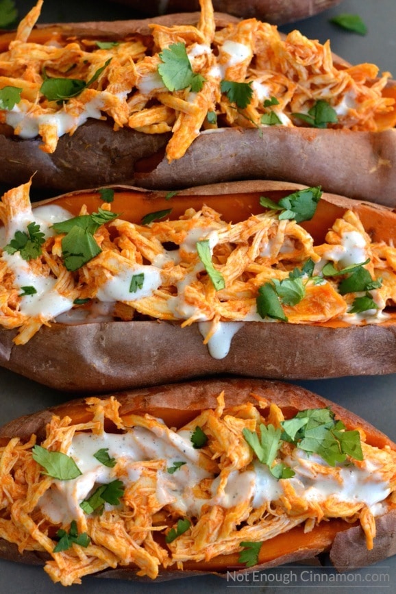 Tender baked sweet potatoes stuffed with shredded buffalo chicken, topped with a sprinkle of green onions and a dollop of Greek yogurt. Sweet meets spicy in this hearty, healthy dinner.