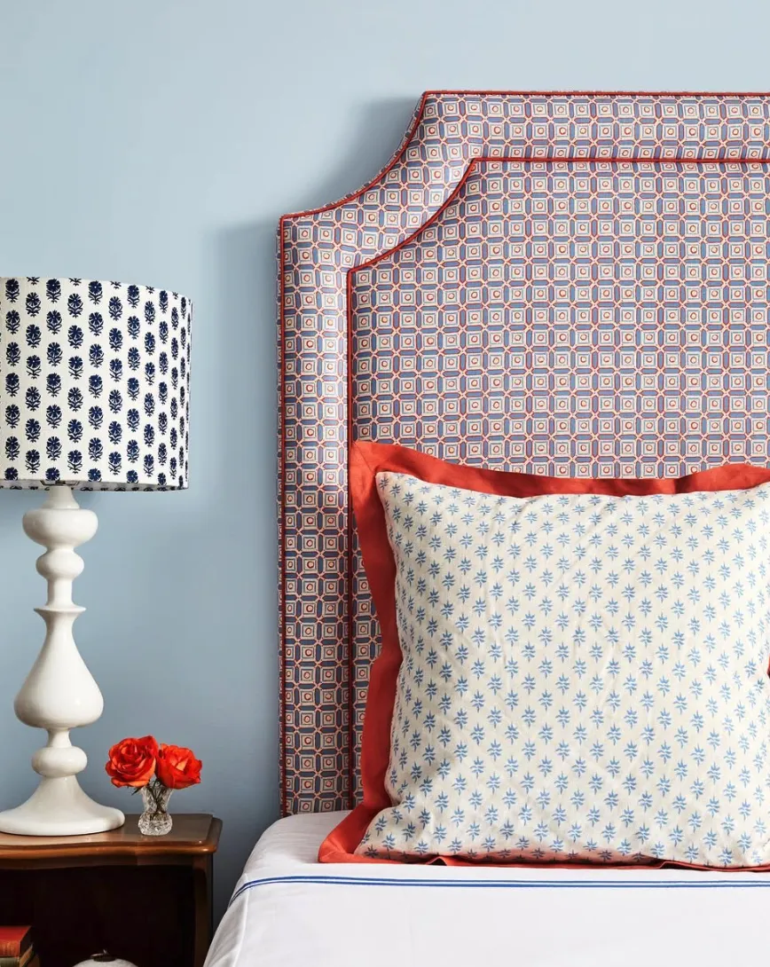 Geometric EleganceThe geometric fabric headboard blends vibrant blue, orange, and white tones, creating a stunning focal point against the soft blue walls. This look works well with matching patterned accessories, like the lampshade, adding cohesiveness to the room. Upholstering a headboard in a fabric like this is a DIY-friendly weekend project if you already have the headboard base and staple gun. Otherwise, consider hiring a professional upholsterer for a perfectly tailored look.