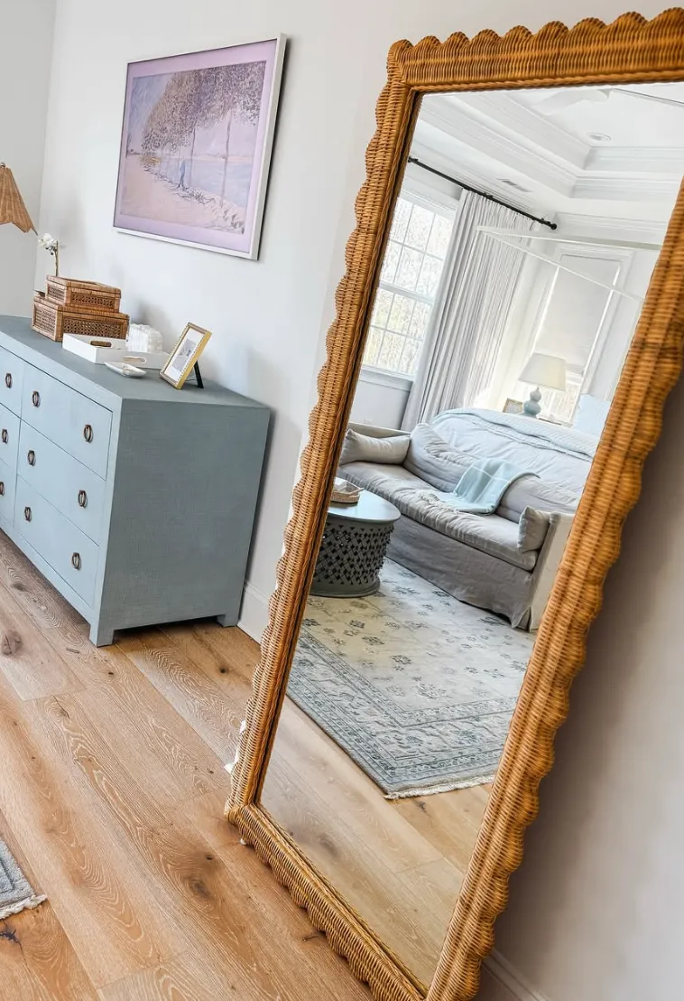 Rustic Elegance with a Wicker FrameThis full-length mirror with a scalloped wicker frame adds a charming, rustic feel to the bedroom. It pairs beautifully with light wooden flooring and a soft blue dresser, creating a space that feels both coastal and cozy. The large mirror also helps to reflect natural light, making the room feel bigger and brighter. For a similar look, consider placing a statement mirror in a corner or near a light source to maximize its impact.