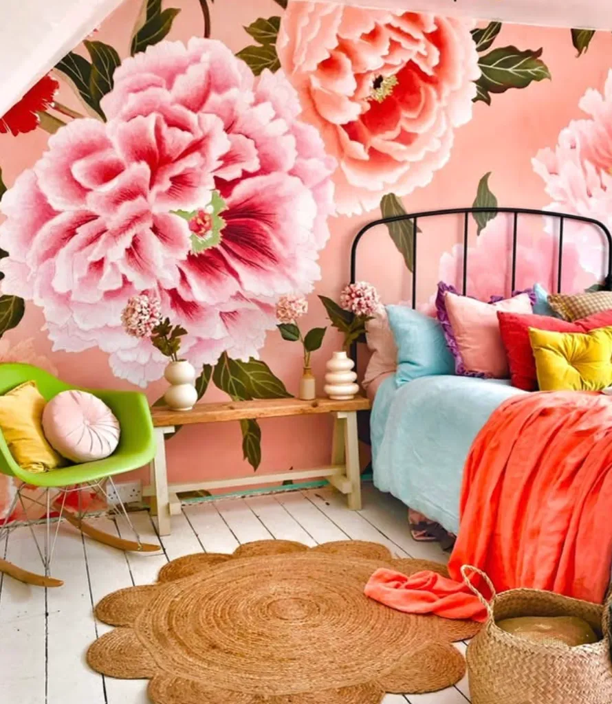 Oversized Floral Mural with Bright Accents A show-stopping mural of oversized pink peonies transforms this bedroom into a garden oasis. Paired with colorful bedding and natural textures like the wicker chair and jute rug, the space feels lively and inviting. This mural could be created by a professional wallpaper installation or an artistic DIY hand-painting project. Expect to spend one to two days bringing this statement wall to life.