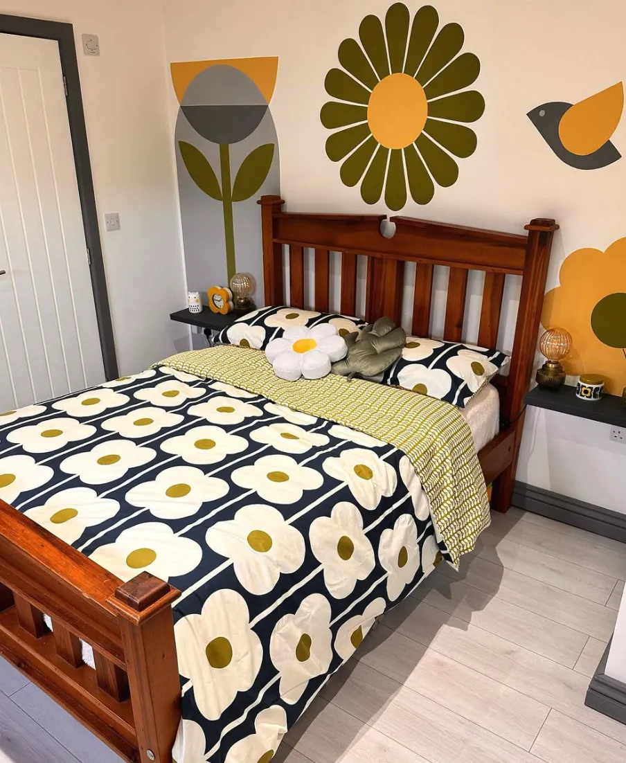 Retro Floral Mural with Vibrant Bedding This bedroom features a retro-inspired mural with bold, graphic flowers in mustard, olive, and grey tones. The coordinated bedding echoes the mural's vintage feel, tying the room together with a playful yet cohesive look. This is a DIY project achievable over a weekend using stencils or freehand designs. It’s perfect for adding personality to a small or minimalist space.