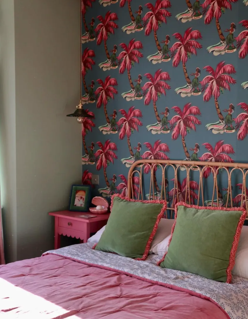 ropical Vibes with a Bold StatementA tropical-themed wallpaper with vibrant red palm trees and teal accents steals the spotlight in this bold bedroom design. The playful print, paired with rich green cushions and a rattan headboard, evokes a sunny, laid-back vacation vibe. This kind of wallpaper works well for anyone wanting to bring personality to their bedroom. Installing traditional wallpaper may require professional help to ensure proper alignment, but peel-and-stick versions offer a quicker, more DIY-friendly option, taking just a day or two to complete.