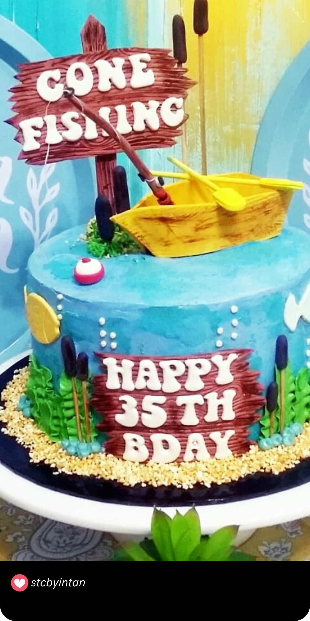 For the man who loves to cast a line, this fishing-themed cake is perfect! The detailed design includes a mini boat, a fishing rod, and a rustic wooden sign that says "Gone Fishing," all set against a water-inspired blue background. 