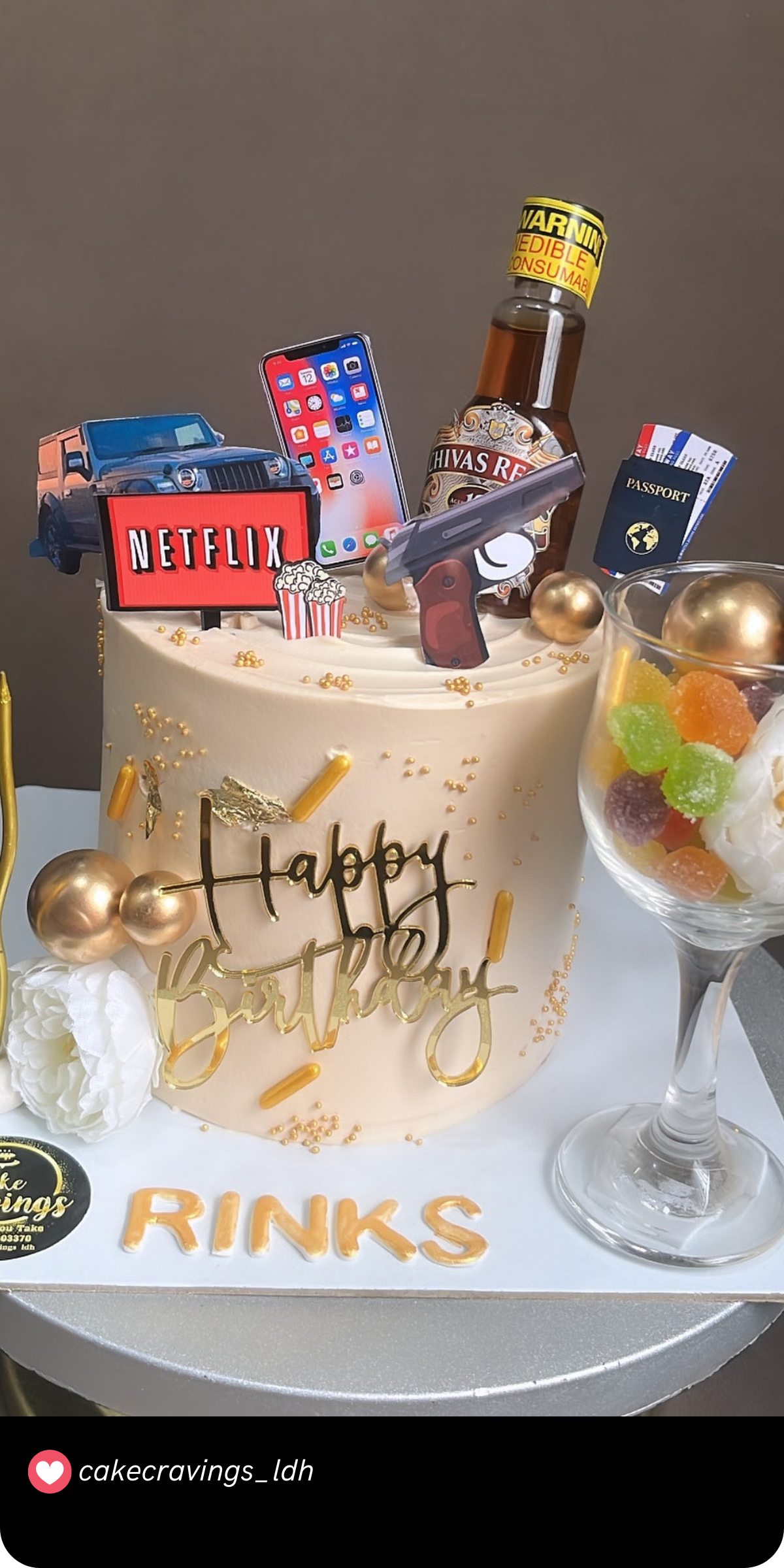 This cake screams luxury with its elements representing a man's favorite pastimes—Netflix, mobile gadgets, travel essentials, and a touch of whiskey. The sleek gold accents and fun details make it a perfect choice for someone who enjoys the finer things in life.