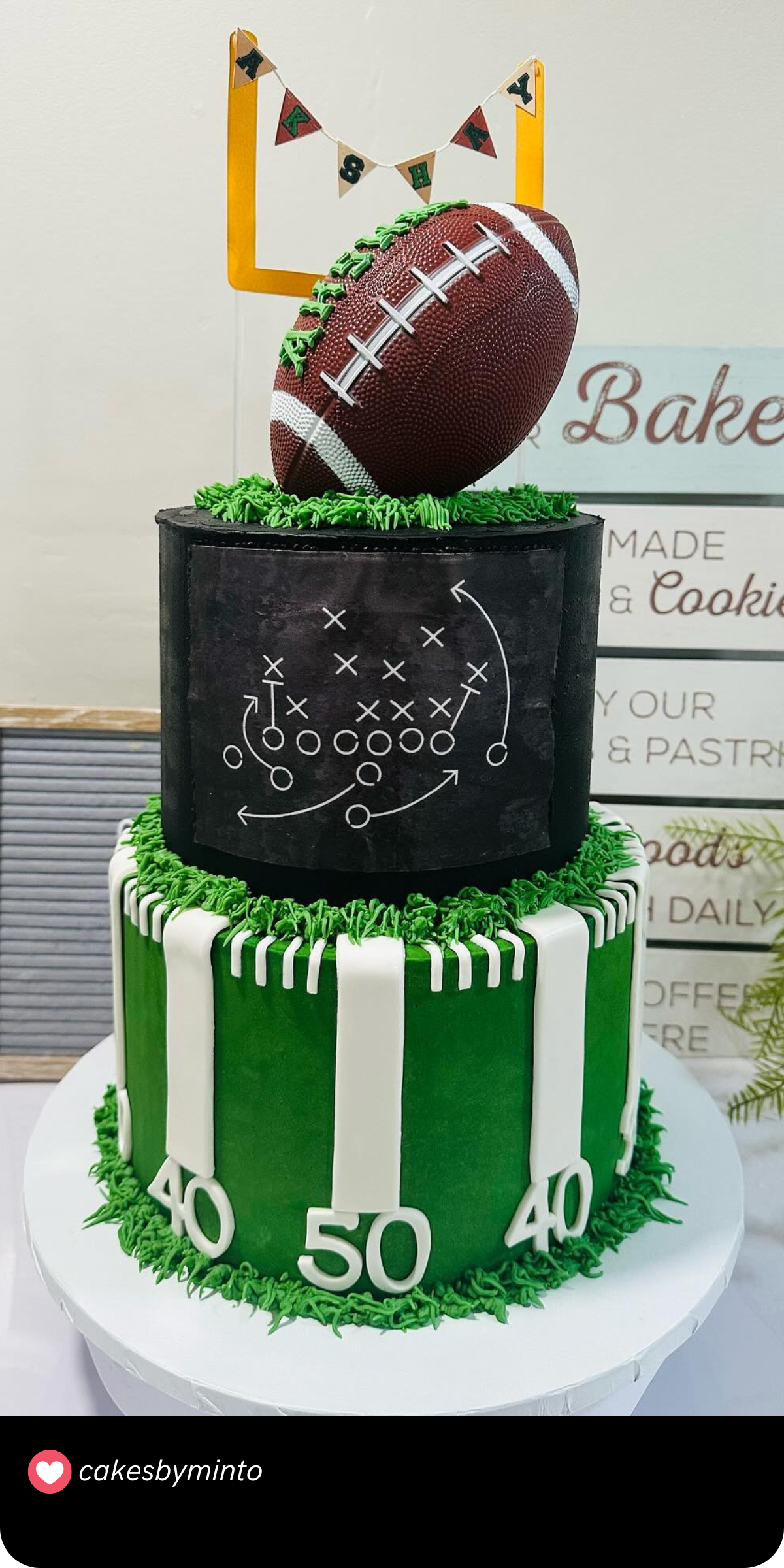 Touchdown! This football-themed cake is perfect for sports lovers. The cake features a detailed football sitting atop a playbook design, with goal posts and yard markers completing the field-themed look. It’s a winning choice for a birthday celebration!