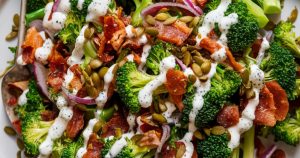 Enjoy a fresh twist on a classic with this broccoli bacon salad, in a tangy lemon dressing. Toasted pumpkin seeds provide a delightful crunch, making it a hit at any get-together! ?? #HealthyRecipes #SaladInspo