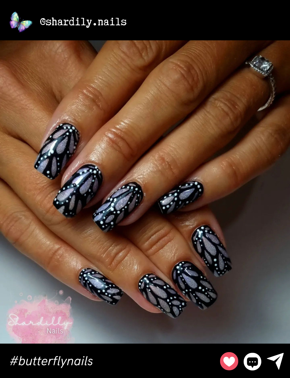 This elegant nail art features a shimmery lavender base overlaid with intricate black and white butterfly wing patterns, giving the nails a delicate, ethereal look.