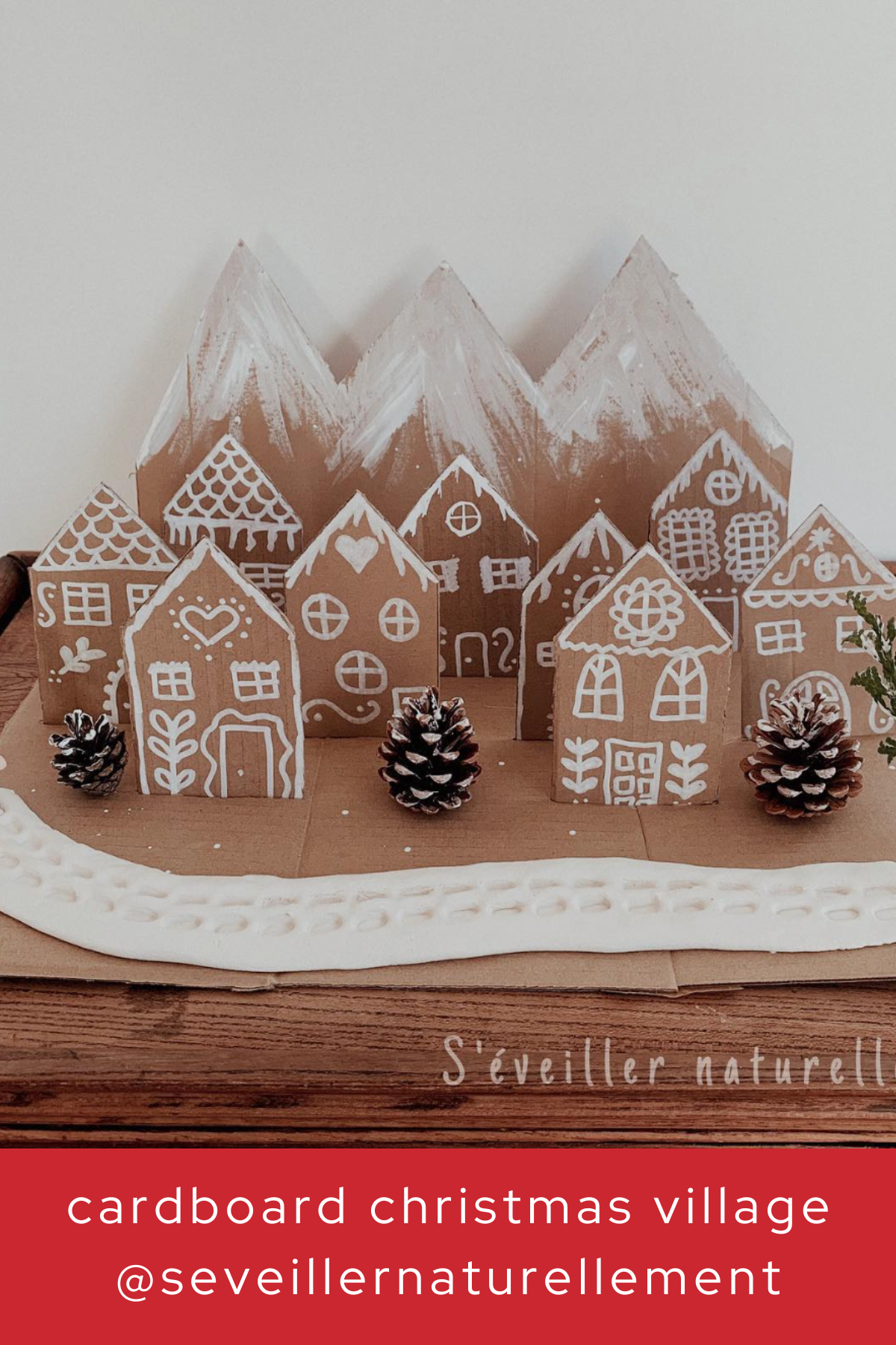 This charming little village is made entirely of cardboard and decorated with white paint to mimic snow-covered rooftops and windows. It’s a beautifully minimalist way to bring Christmas cheer to your decor, with pinecones adding a natural touch.