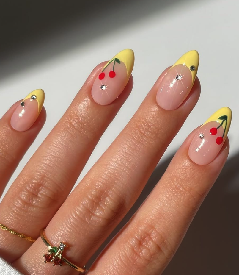 Sunny and Sweet 🍋🍒: Yellow French tips with tiny cherries? These nails are basically sunshine on your hands.