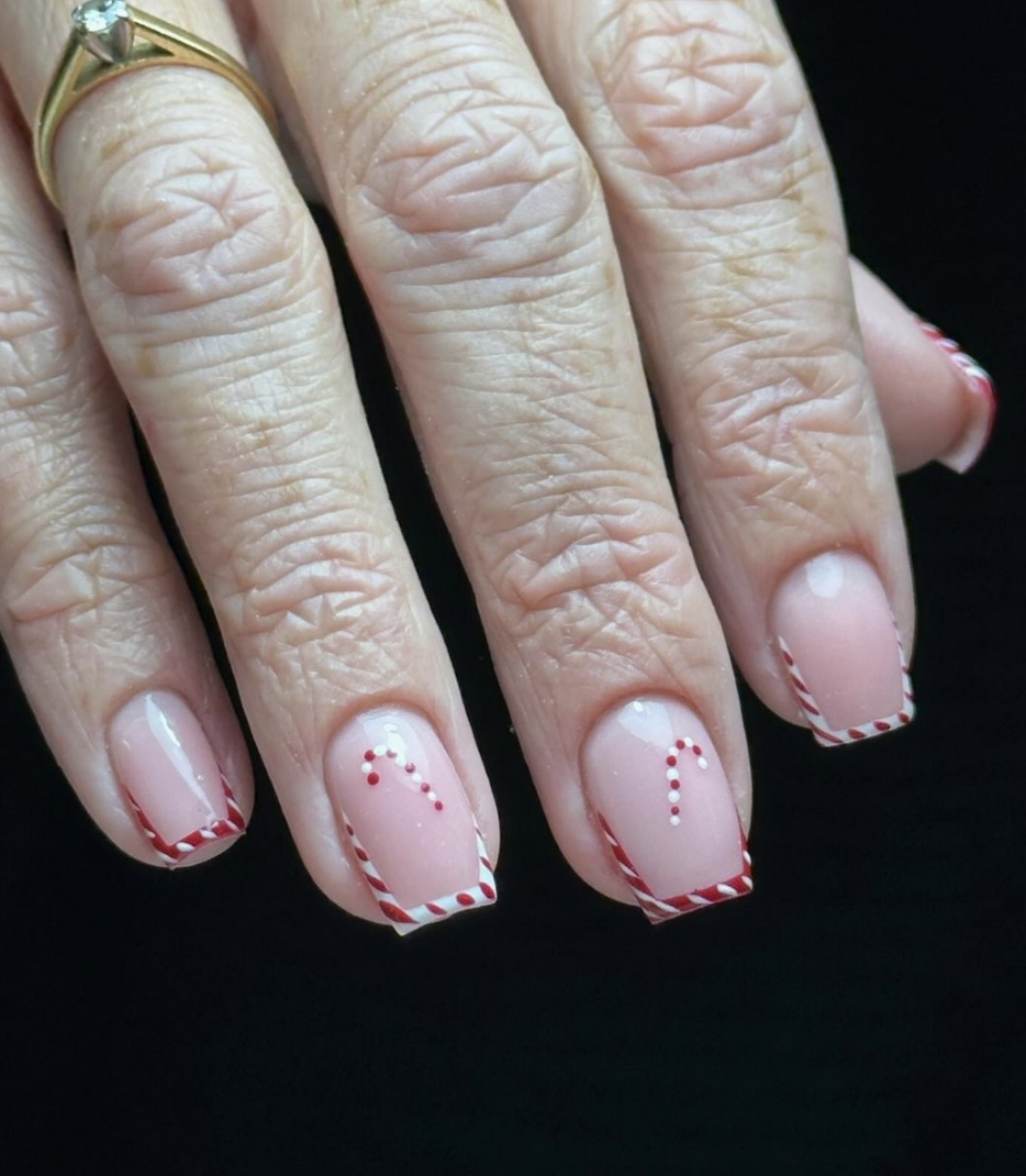 Candy Cane French Tips: A nude base with candy cane-inspired tips adds a festive twist to the classic French manicure. This design is subtle yet full of holiday spirit, perfect for any Christmas occasion. @nail_it_with_corrine