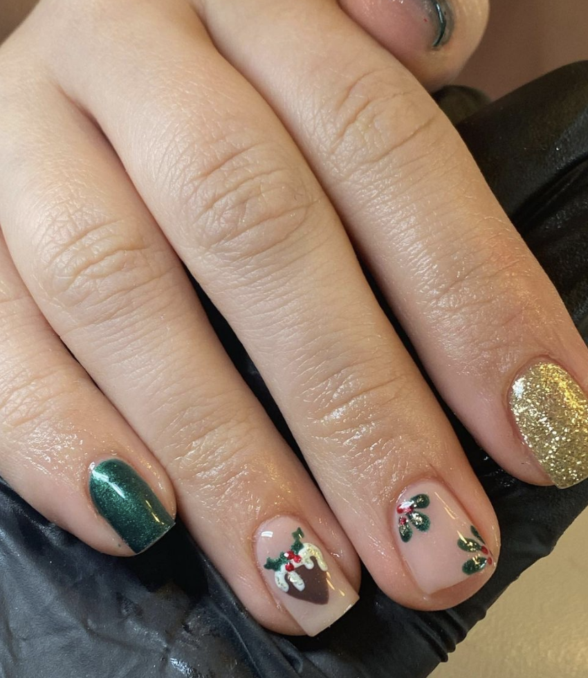 Festive Holly & Glitter: With a mix of green, gold, and holly-themed accents, this design combines the rich colors of the season with a touch of sparkle. The Christmas pudding accent nail adds a fun, unique twist. @nailed_byemily