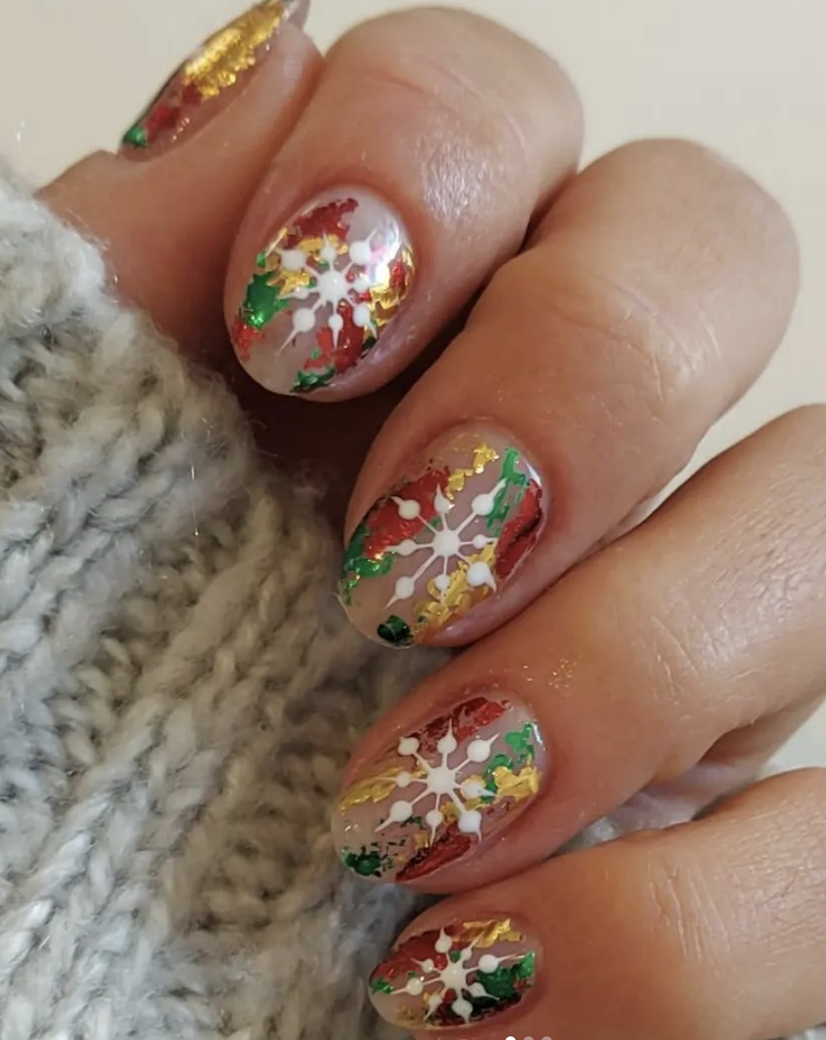 Metallic Festivity: Colorful foil and snowflakes on a clear base create a frosty, glittery effect reminiscent of holiday decorations. This design gives off a luxe, wintry feel while keeping it understated. @krystlenailsandbeauty