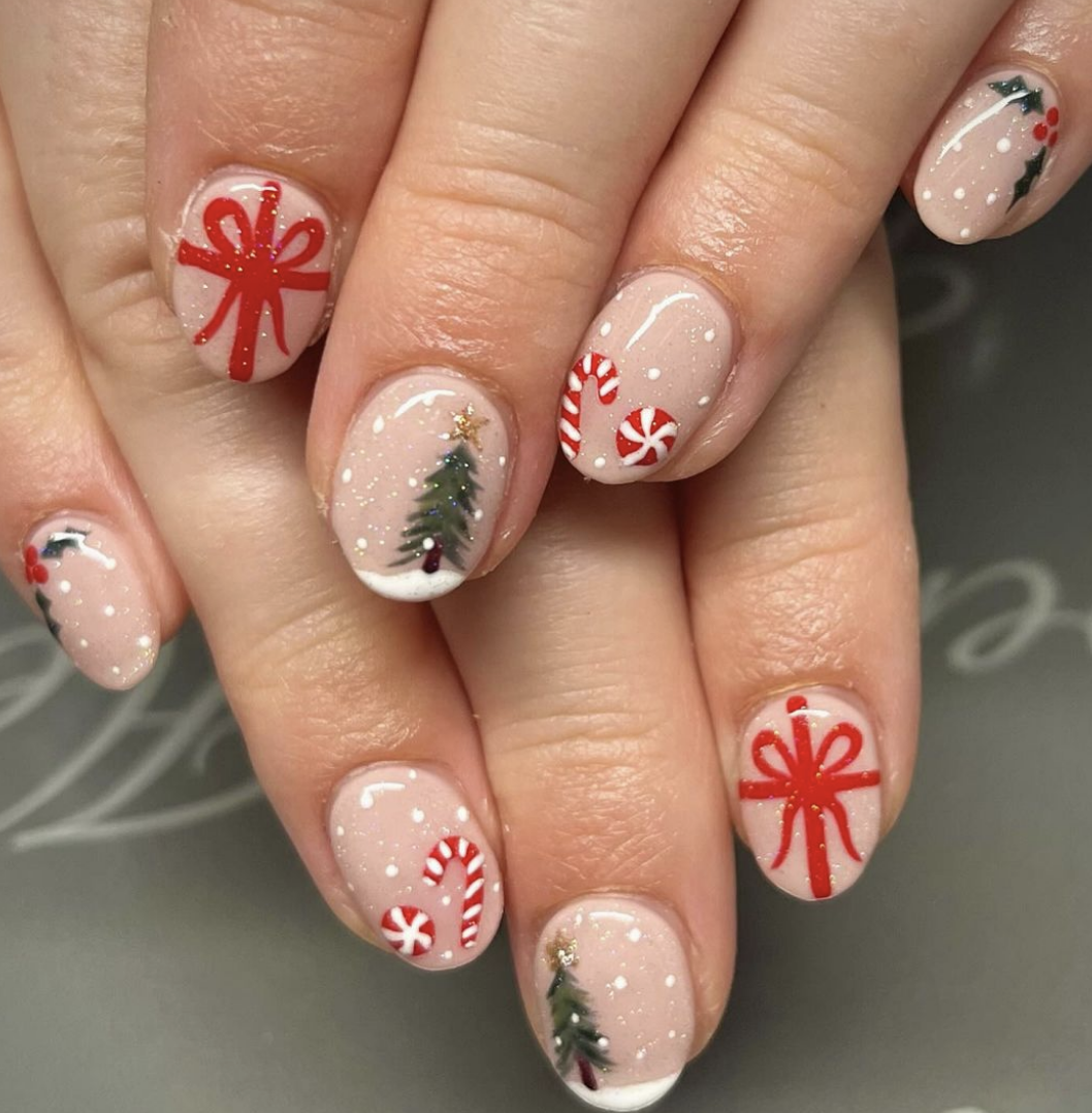 Gift Wrapped & Sparkling: Beige nails feature holiday-themed art with red bows, candy canes, and snow-dusted trees. The look is whimsical yet classic, bringing the charm of a wrapped present to your fingertips.