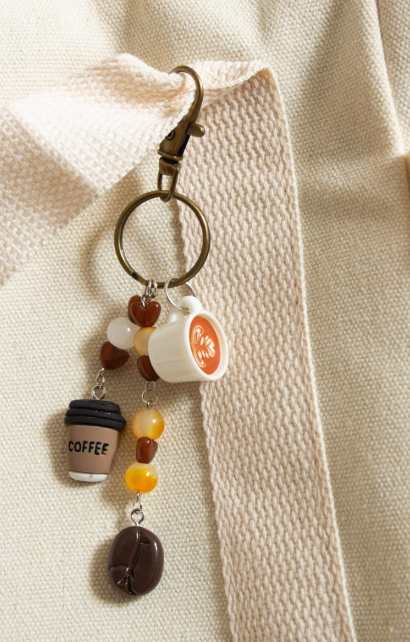 This adorable keychain features a collection of charms that celebrate your love for coffee:A tiny, detailed cup of latte art with a realistic design.A charming coffee cup that adds a touch of warmth to your keys or bag.Beautiful beaded accents in shades of brown and cream, adorned with sweet heart-shaped beads.A mini coffee bean charm that completes the coffee lover's dream.