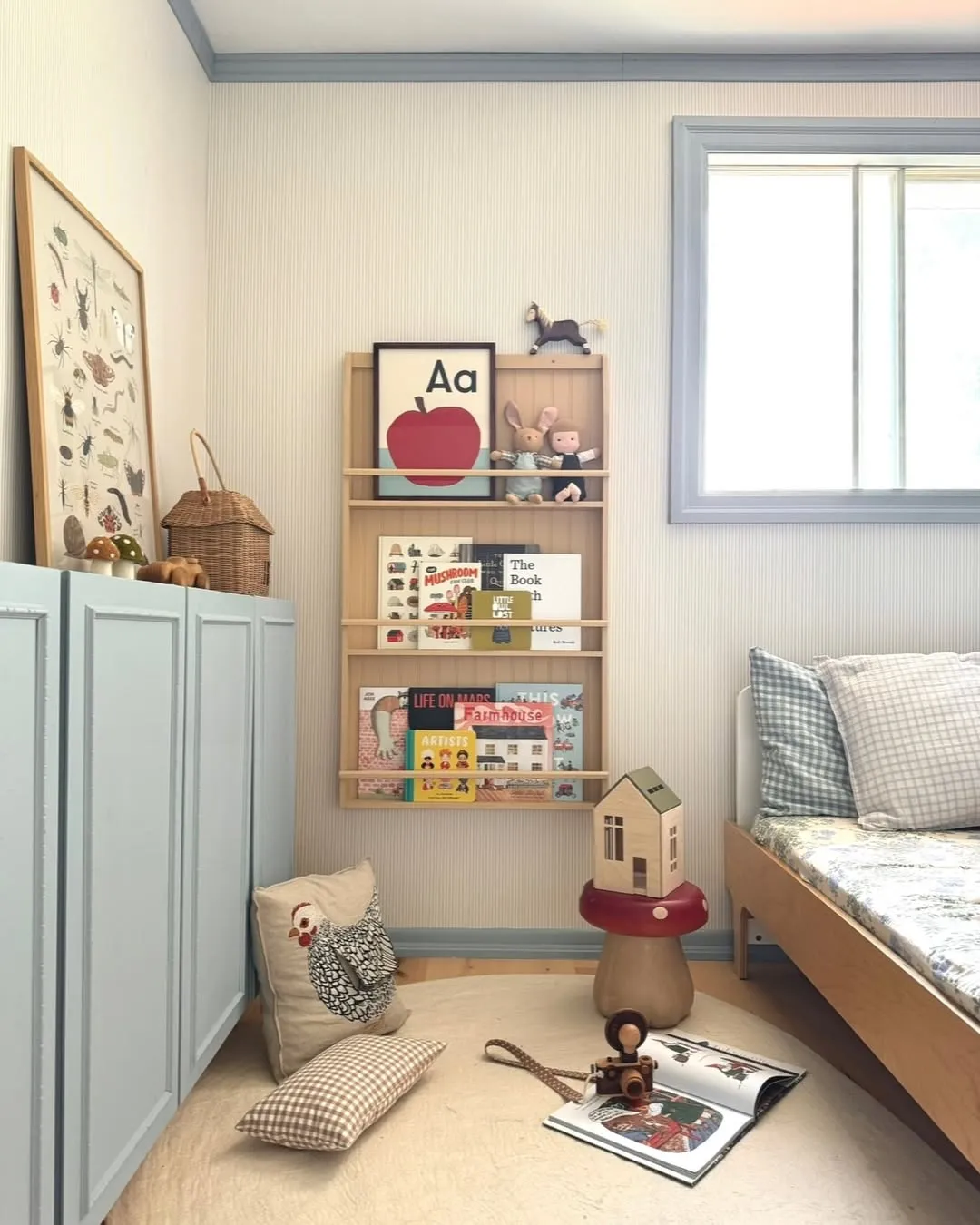 "Reading Corner Bliss" – Wall-mounted book racks keep stories accessible while encouraging little ones to grab their favorite tales. Plus, the mushroom stool? Too cute!