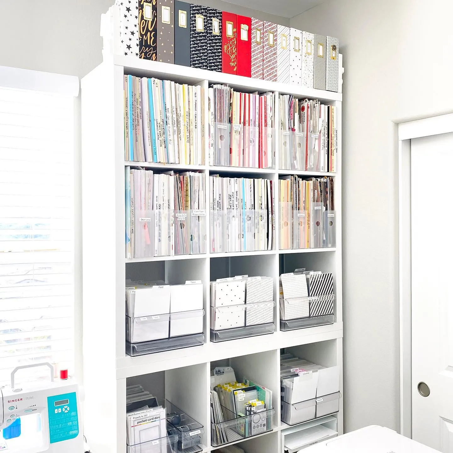 A towering bookshelf with labeled storage bins keeps craft paper, stickers, and supplies ultra-organized—plus, clear containers make it easy to see what you have!