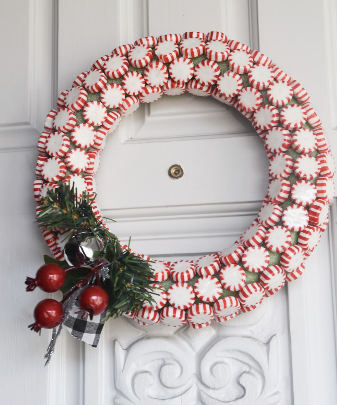 For a pop of whimsy, this peppermint wreath uses red and white stripes that look good enough to eat! It’s a unique and playful touch that’s perfect for candy cane lovers. Make it here.