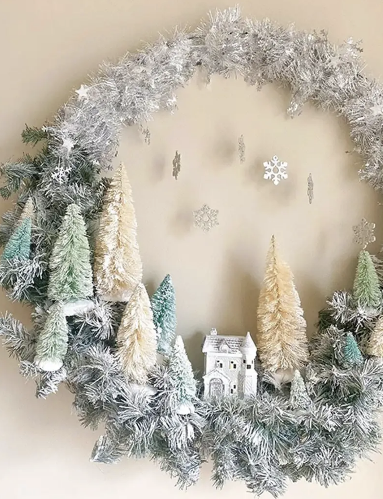 Bring a cozy village scene to your front door with this Christmas Village wreath! Using mini houses and simple Dollar Store supplies, this wreath creates a charming little world that feels like a holiday story. Make it here.