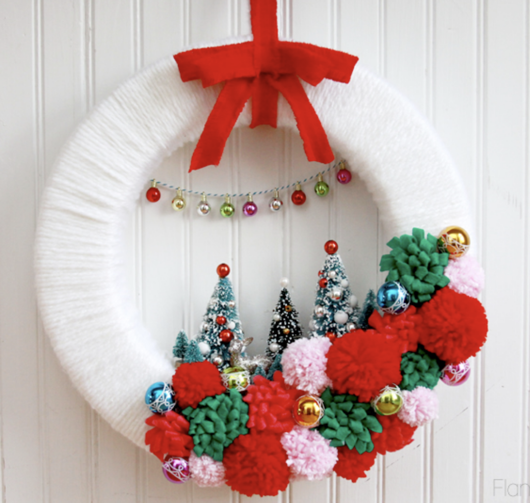 Add charm to your front door with this Christmas village wreath! With little houses nestled in greenery, it’s a whimsical holiday project. Make it here.