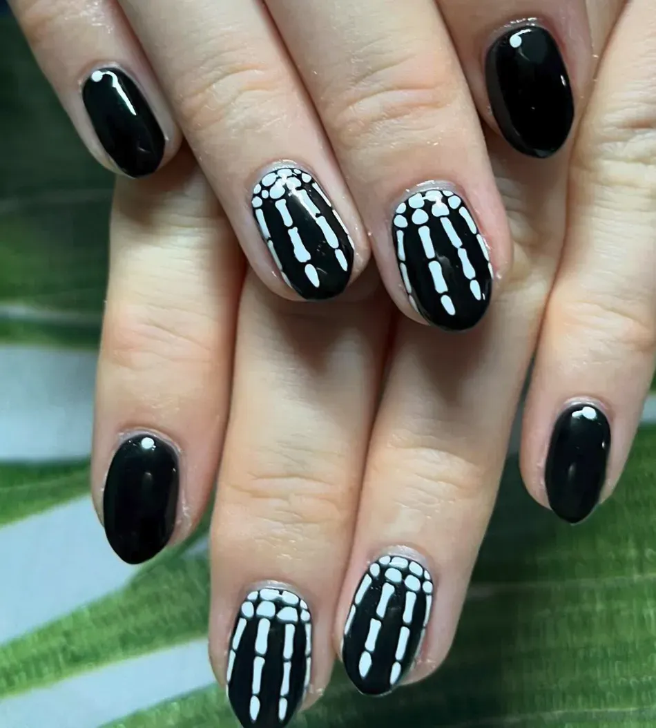 Skeleton Fingers – Black polish with simple white bone details—such an easy Halloween nail idea to try at home.
