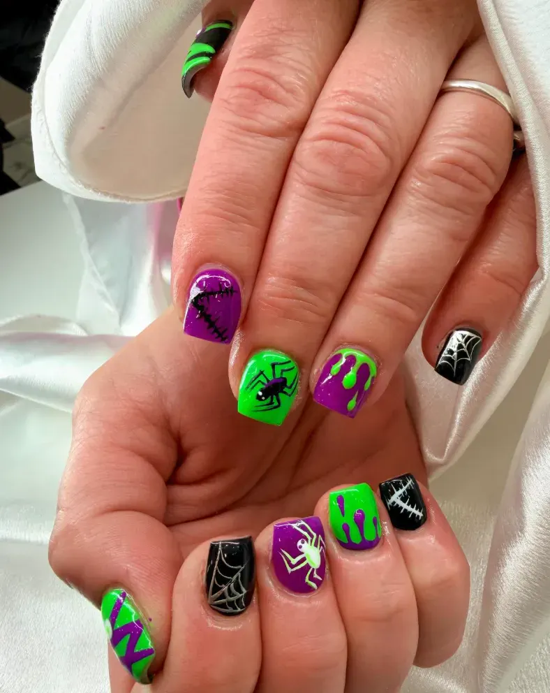 Neon Spider Vibes – Bright green and purple spiders with drips make these bold at home Halloween nails a total standout.
