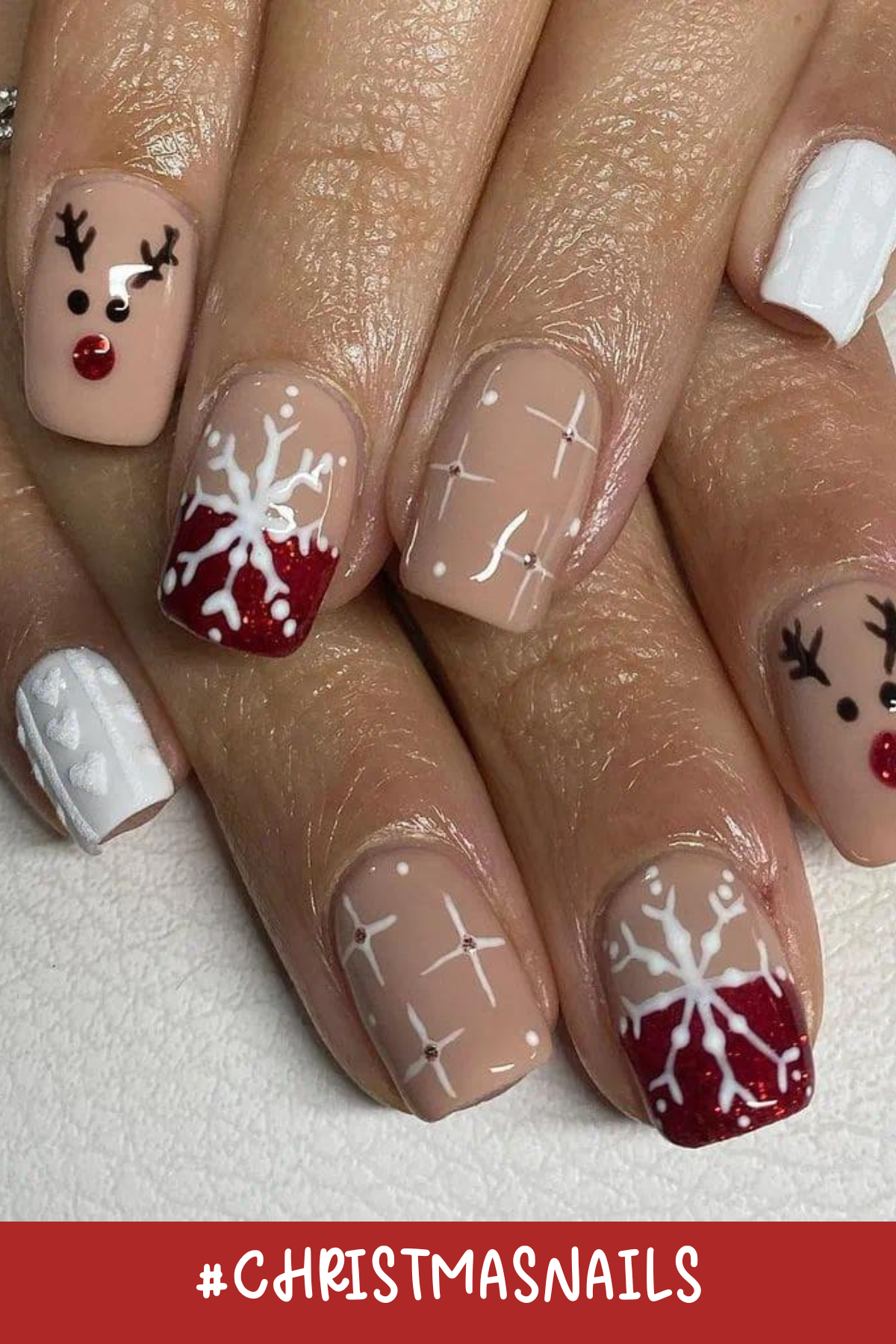 How adorable are these reindeer nails?! With a nude base and pops of white and red, this set has everything from sparkly snowflakes to Rudolph’s shiny red nose. Perfect for spreading some holiday cheer!