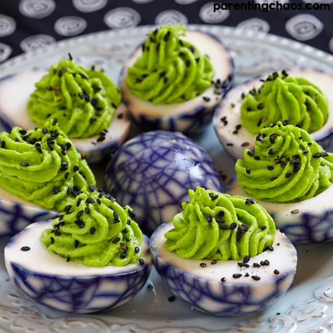 These spooky deviled eggs are dyed with a wicked purple spiderweb effect and piped with a ghoulish green fillingâsinister enough for your Halloween buffet, but totally delicious!
