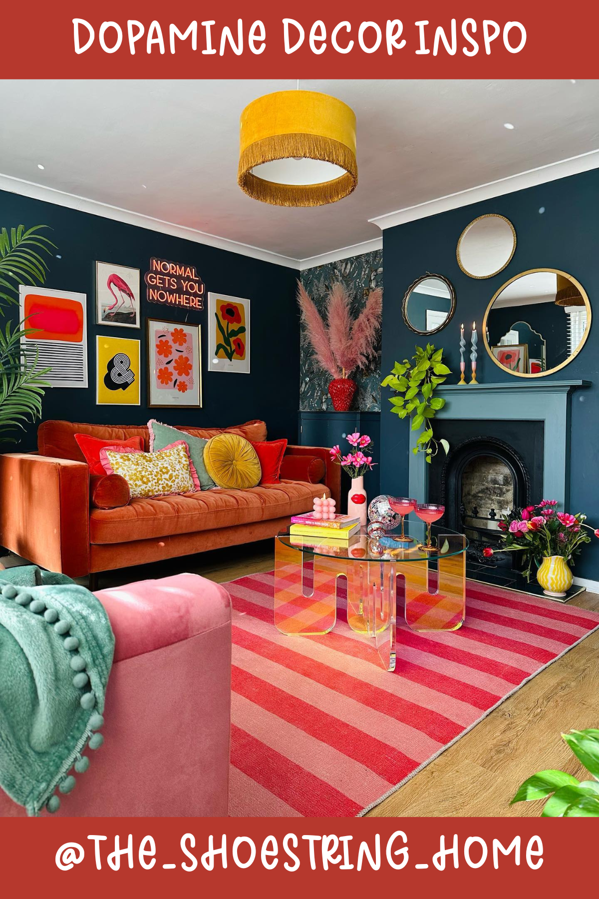 @THE_SHOESTRING_HOMECozy meets cool in this living room! 🛋️ Deep teal walls serve as a chic canvas for vibrant artwork and an inviting orange sofa piled high with textured pillows. A striped rug and mismatched mirrors create layers of interest, while plants and neon signs keep things fun and fresh!