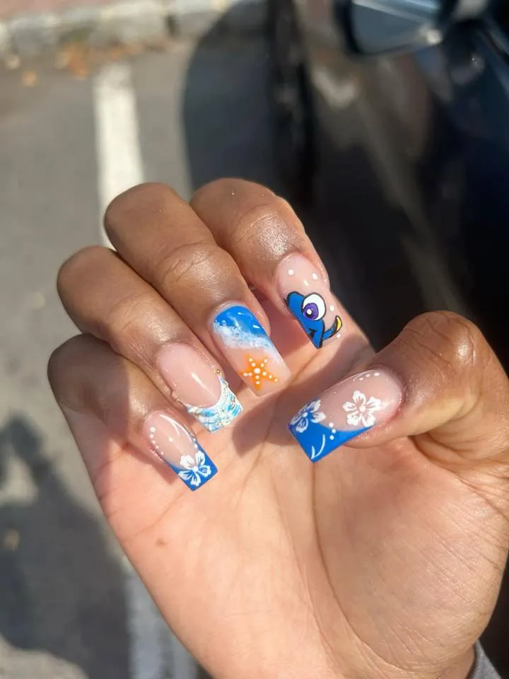 These beachy nails capture ocean life with bright blue French tips, starfish details, and a tiny Dory accent. They’re fun, summery, and perfect for your next Disney vacation.