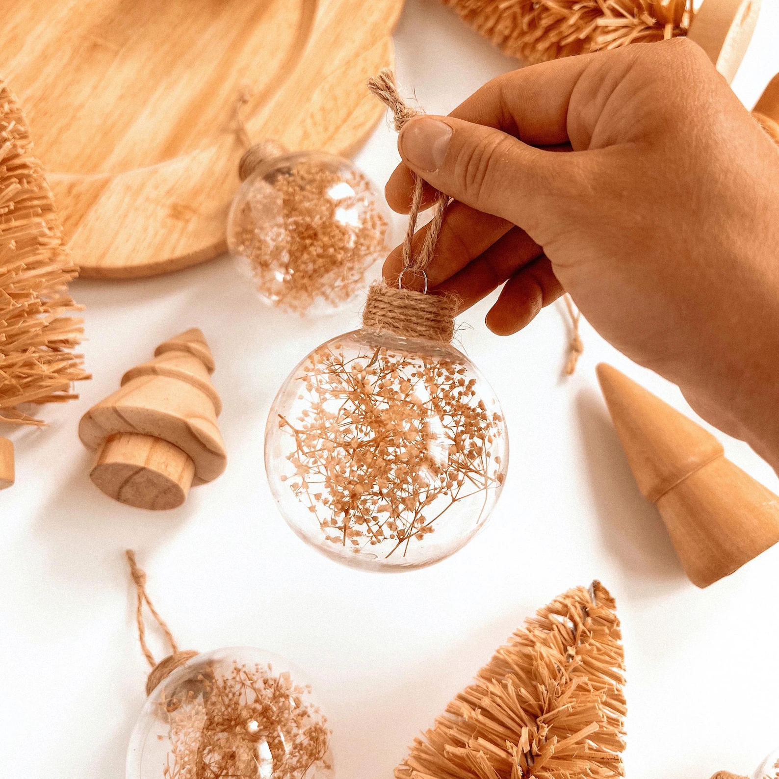 These dried floral ornaments are the definition of understated elegance. Each one is handmade with real dried flowers sealed inside a clear shatterproof bulb — simple, timeless, and effortlessly beautiful. The soft neutral tones fit perfectly with boho or minimalist Christmas decor, adding a natural, organic touch to your tree. Bonus: they make the sweetest little gift toppers that double as keepsakes long after the holidays are over.