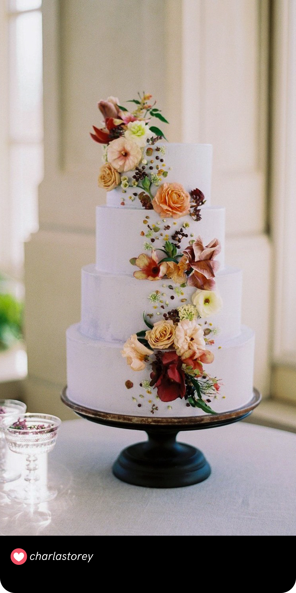 Harvest-Inspired Charm: This cake beautifully captures the essence of autumn with its mix of vibrant florals and rustic textures, making it an ideal choice for a fall wedding.