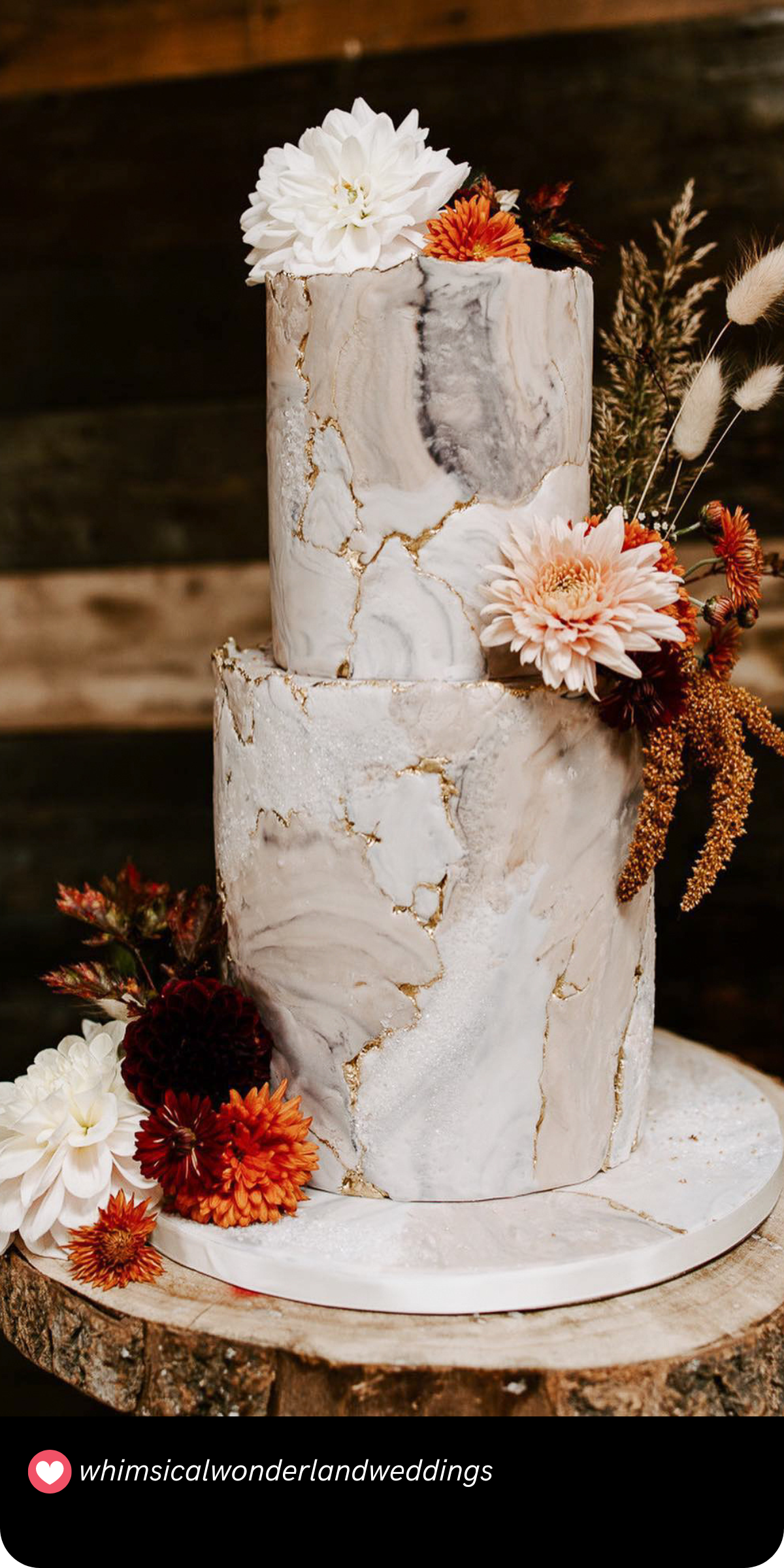 Marbled Fall Beauty: Embrace the elegance of autumn with this marbled cake, adorned with delicate fall flowers and golden accents, perfect for an autumn wedding celebration.