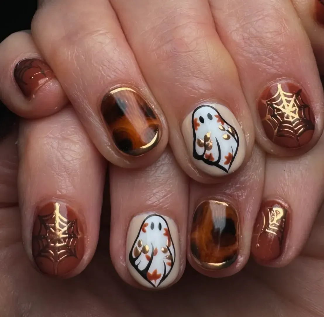 8. Autumn Chic Ghosts 🕸️🍁This short-nail design nails (pun intended) the balance of cute and classy. Think tortoiseshell marbling, copper spiderwebs, and white ghosts sprinkled with delicate falling leaves. It’s giving cozy October sweater weather while still keeping a playful Halloween edge.