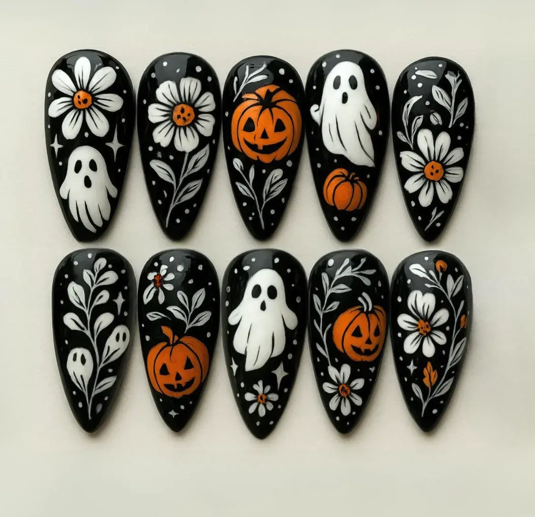 7. Gothic Garden Ghosts 🌼🎃If you’re after something a little moodier, these black glossy nails deliver. Ghosts, pumpkins, and flowers are hand-painted in crisp white and orange, with leafy accents and tiny stars scattered across the set. It’s like vintage Halloween art, but make it mani-worthy. Perfect for anyone who loves classic spooky Halloween nails with a stylish twist.