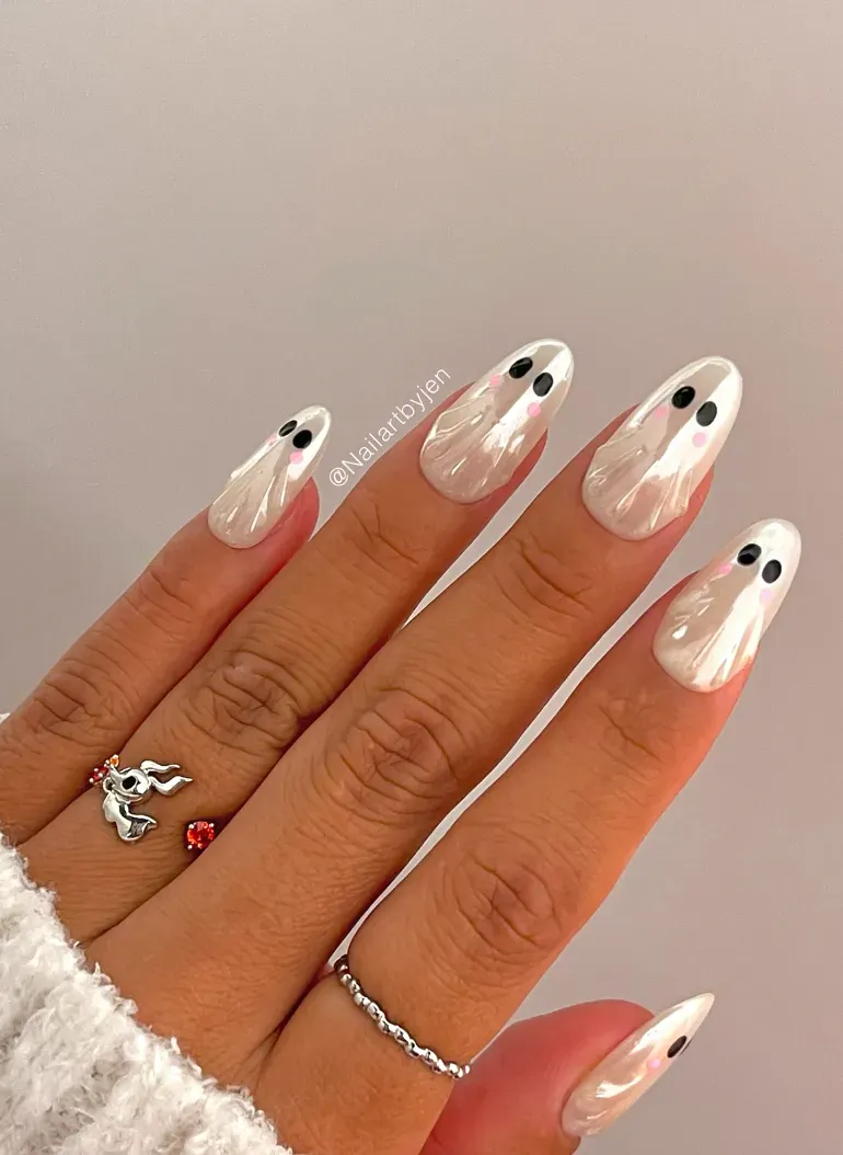 5. Shimmery Classic Ghosts 👻💫Sometimes less is more, and these pearly white nails prove it. Simple, glossy ghosts with rosy blush cheeks give this design a sweet, almost ethereal vibe. It’s classy, chic, and still perfectly Halloween—ideal if you want ghost nail art that works for the whole month of October, not just a party night.