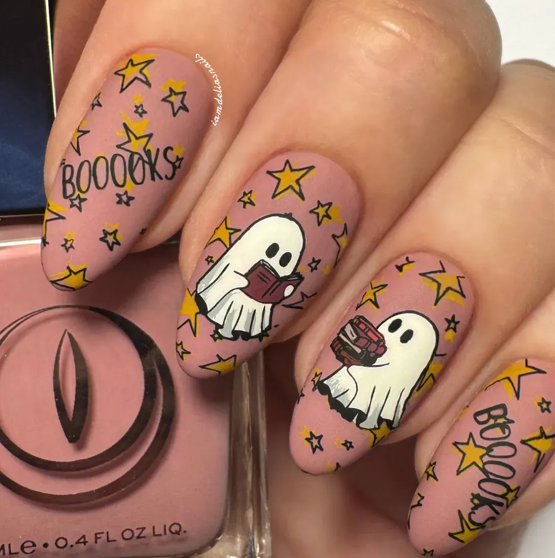 Book-Loving Ghosts 📚👻How adorable is this set? These little ghosts are obsessed with boooooks (same, little ghost, same). On a dusky pink base, you’ve got stacks of books, tiny ghost readers, and pops of yellow stars for that magical October night energy. It’s a spooky-meets-cozy look that’s perfect for bookworms who want Halloween nails with a whimsical twist.