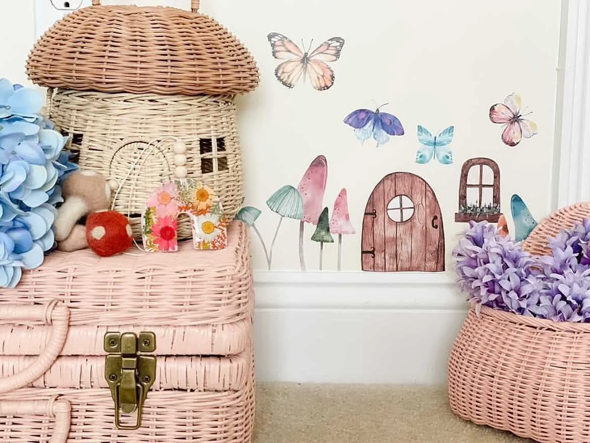 Fairy Garden Vibes – Wicker baskets, hand-painted mushroom decals, and delicate floral accents bring a touch of woodland magic to this playroom corner.