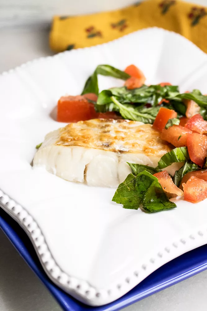 Raise your dinner game with this Parmesan Haddock recipe, topped with fresh tomatoes and fragrant basil. Perfect for a quick and tasty weeknight meal! #QuickRecipes #SeafoodLovers #HealthyEating